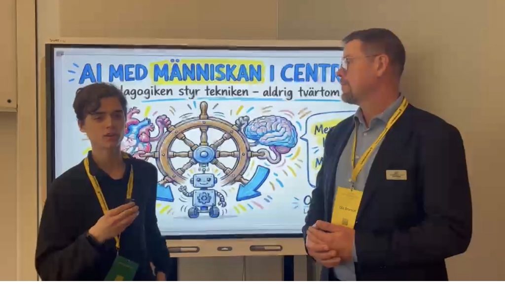 En elev med en liten mikrofon i handen intervjuar en man i kavaj och namnbricka. De står framför skärmen med bilden “AI med människan i centrum”.